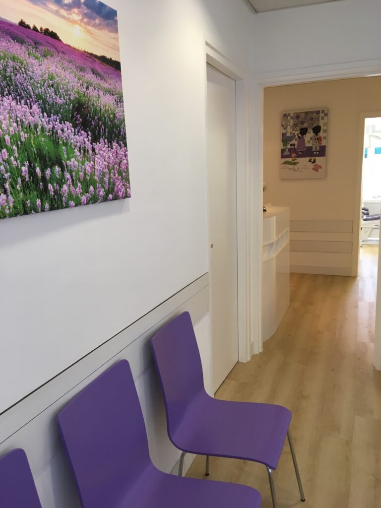 Lichte gang met paarse wachtstoelen