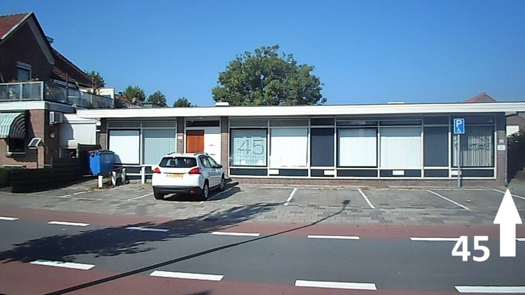 Parkeerplaatsen voor de praktijk; de ingang van nummer 45 is aan de rechterzijde